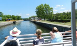a group of people sitting on a bench next to a body of water